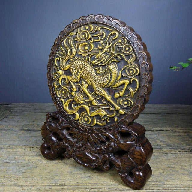 This vintage table screen is carved from sandalwood and features a central roundel in relief, depicting a qilin — a...