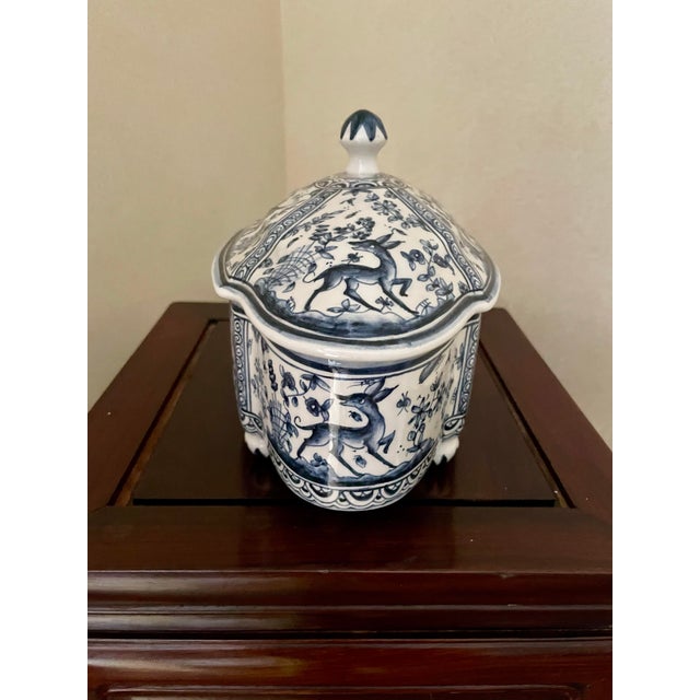 Lovely blue and white painted oblong box with ball feet. The scenes show an animal prancing around a garden.