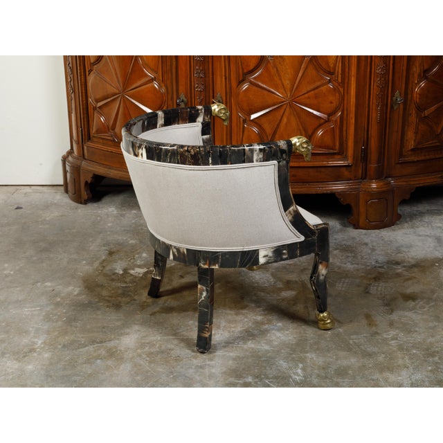 An Italian vintage horn tub chair from the mid 20th century, with gilt rams' heads and new upholstery. Created in Italy...