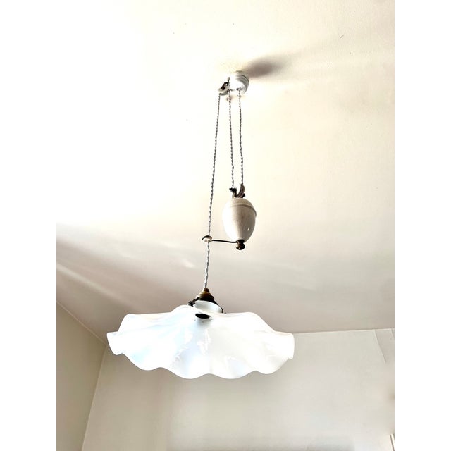 Early 20th-century ceiling pendant light with a "raise and lower" design. White opaline glass shade. This unique ceiling...