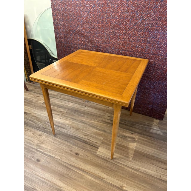 A rare matched dining set by Tomlinson of High Point, Inc.: four armchairs and an expandable table in wood with woven...