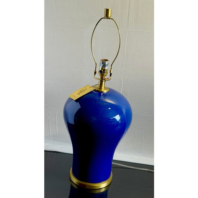 An absolutely striking pair of Ralph Lauren ceramic table lamps in a rich cobalt blue glaze with warm brass-tone hardware....