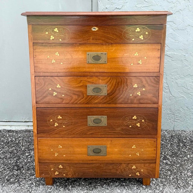 A distinctive vintage wooden jewelry or silverware chest featuring rich wood grain, decorative floral inlay, and campaign-...