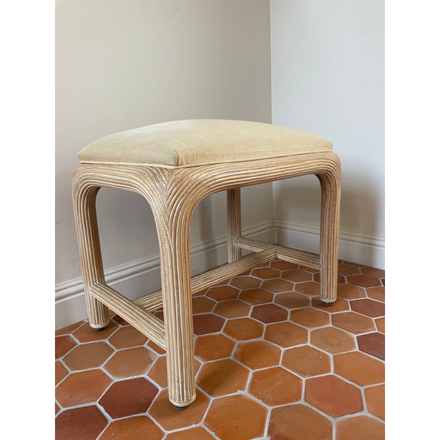 Elevate your space with a touch of organic Postmodern luxury with this vintage 1980s pencil reed rattan vanity stool bench...