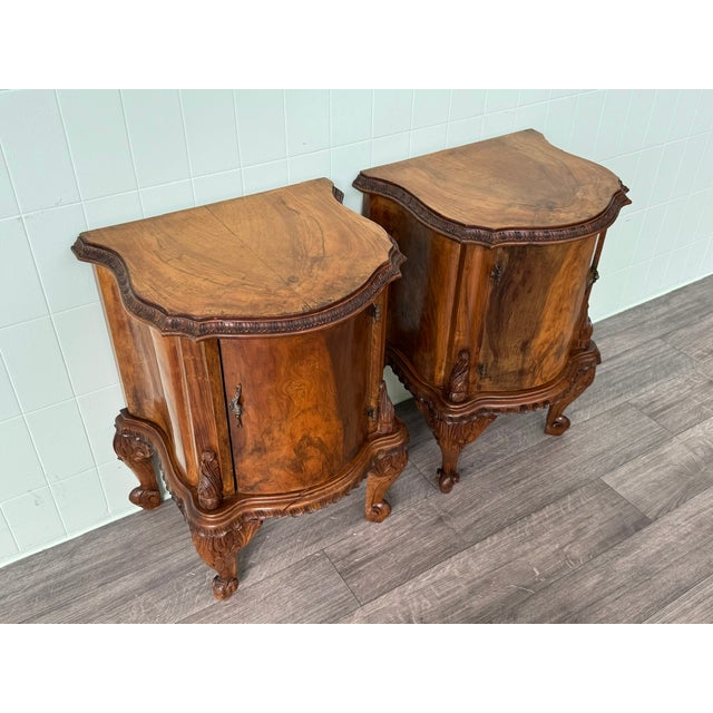 Pair of walnut bedside tables with finely crafted curved legs, embellished with elegant carvings and various details. The...