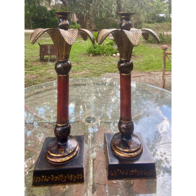Pair of Chinoiserie style tall metal column with gold accents candlestick holders with palm leaf tops and footed pedestal...