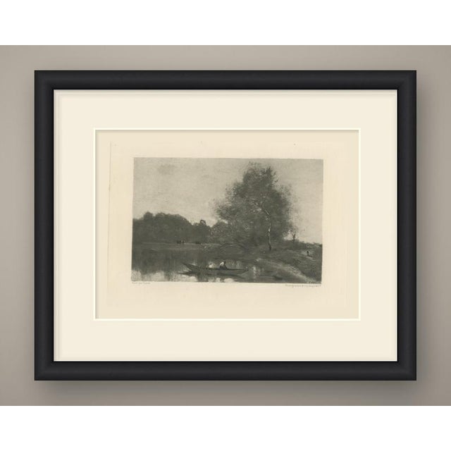 A man in a white shirt bends over in a long, flat-bottomed punt drifting among the reeds of a still river, in this quiet...