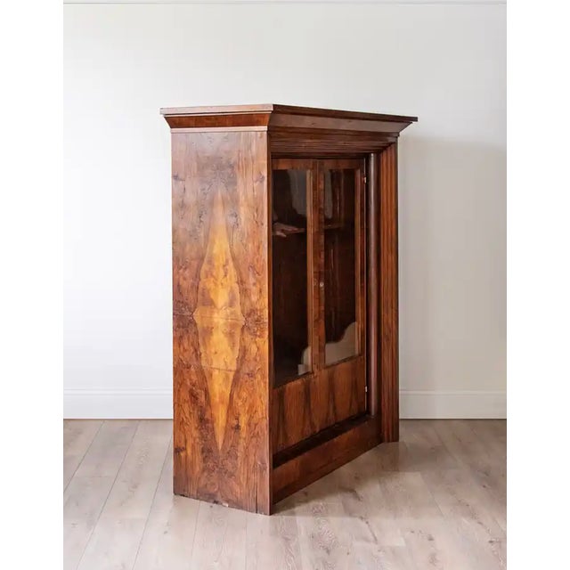 A handsome 19th-century Italian walnut bookcase or display cabinet, distinguished by its strong architectural proportions...