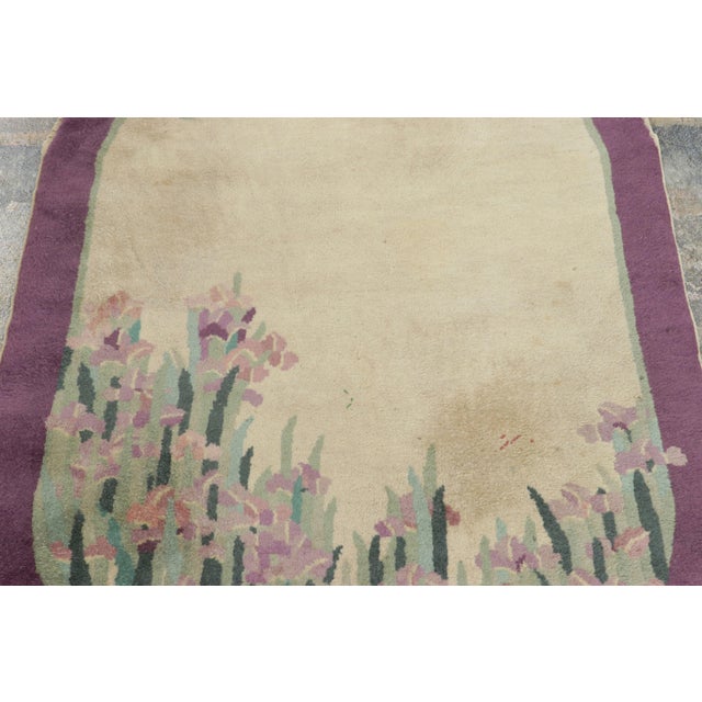 Hand-knotted in wool and originating from China circa 1920–1930, this 3x5 antique Chinese Art Deco rug is a rare...