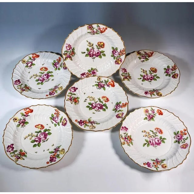 Six early porcelain plates with polychrome floral painting: small bouquets of meadow flowers in iron red, purple, yellow...