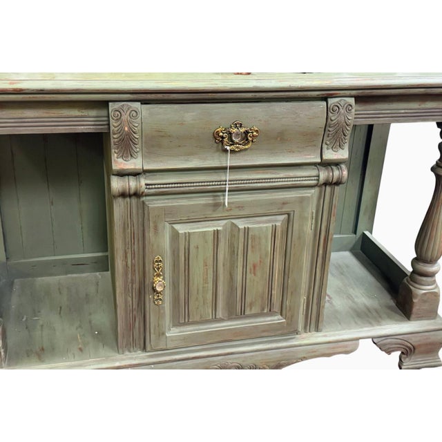 vintage green distressed console table features turned legs, a central drawer over a single door , and lower storage...
