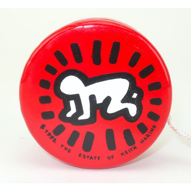 Keith Haring (1958-1990) red lacquered wood YoYo featuring his iconic image entitled 'Radiant Baby'. This design was...