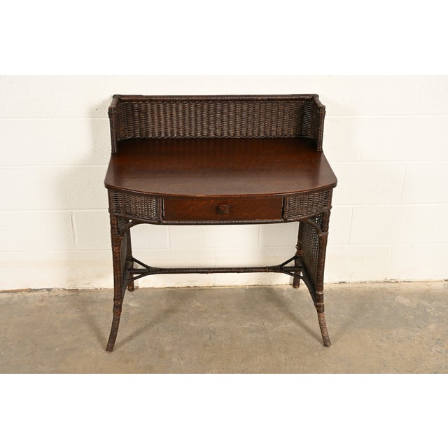 A gorgeous Mission or Arts & Crafts wicker writing desk By Heywood-Wakefield USA, Circa 1890s Oak and woven rattan with...