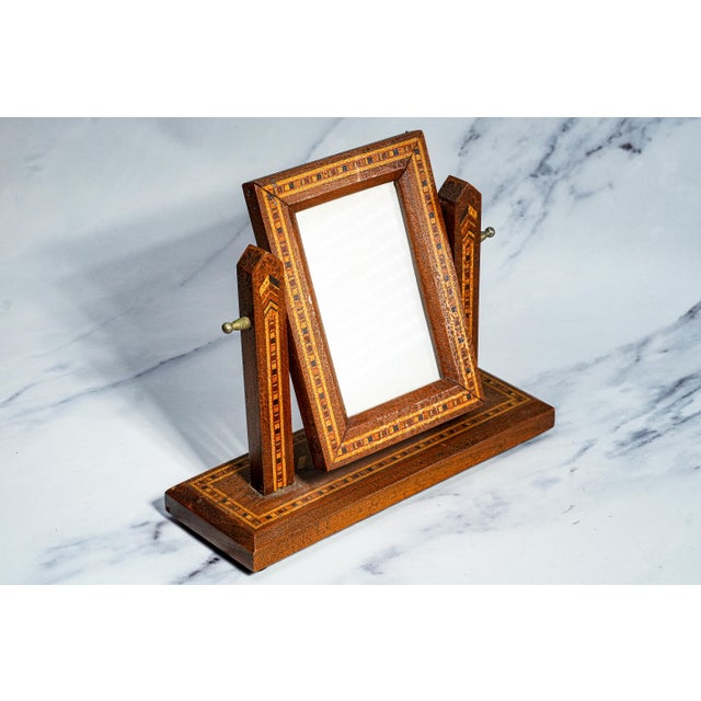 This elegant early 20th century tabletop picture frame is a beautifully crafted decorative object that blends refined...