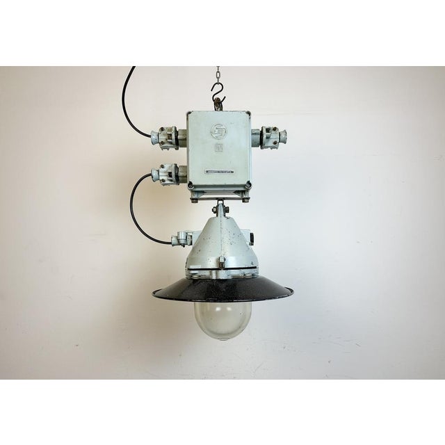 Grey industrial lamp with massive protective glass bulb made by Elektrosvit in former Czechoslovakia during the 1970s.It...