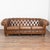 Set of (3) vintage Chesterfield-style seating including one 3-seat sofa and two matching club chairs. Brown tufted leather...