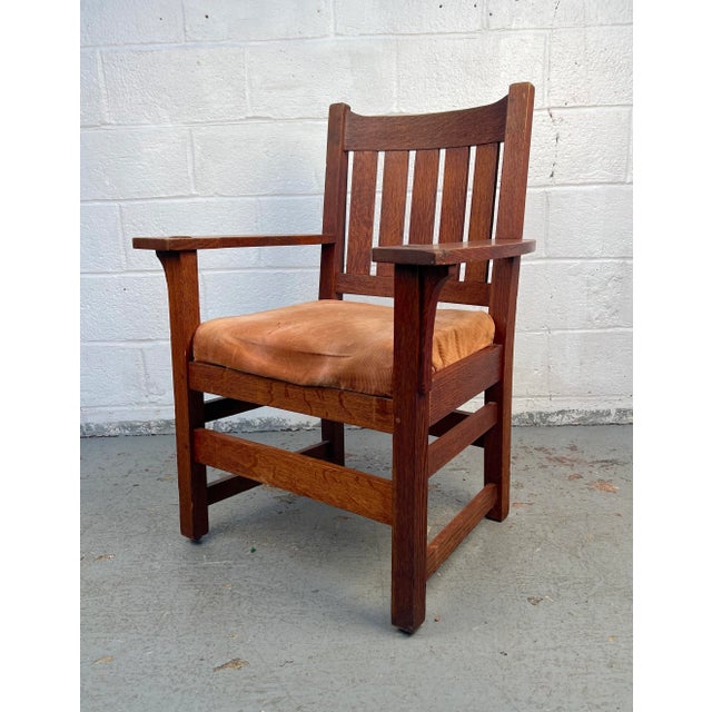 Classic vintage mission oak chair. The design is complemented by an upholstered seat cushion, balancing durability with...