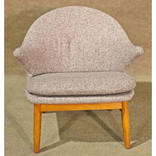 Mid-century modern style lounge chair with arms. Round back design with tapered wood legs.