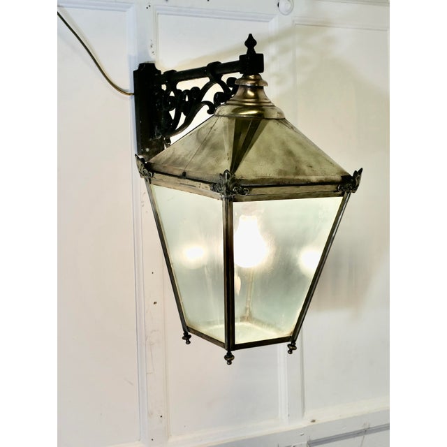Large Brass Wall Hung Lantern This is an old pub light, the Large Brass Wall Lantern is made in brass and hangs on a black...