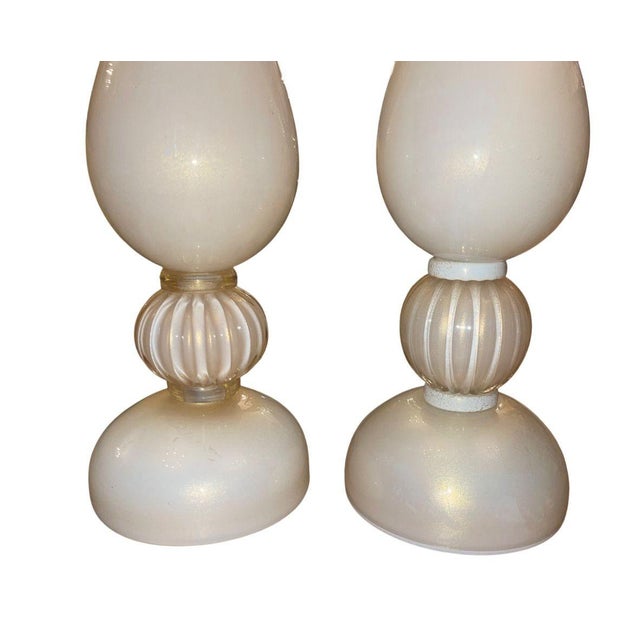 A beautiful similar pair of mid-century Murano glass table lamps in luminous cream-toned glass infused with delicate gold...