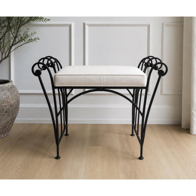 A charming vintage wrought iron vanity bench featuring an elegant neoclassical-inspired design with distinctive concentric...