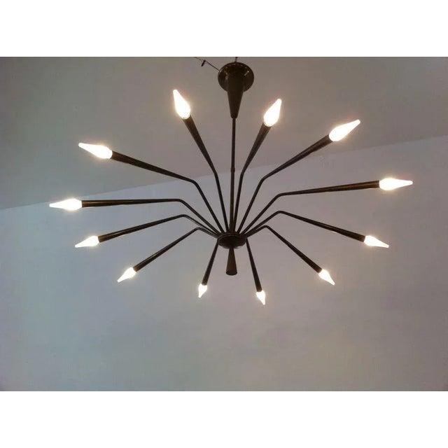 A sculptural 1960s brass Italian sputnik designed by Oscar Torlasco for Lumi. Twelve-light sources.