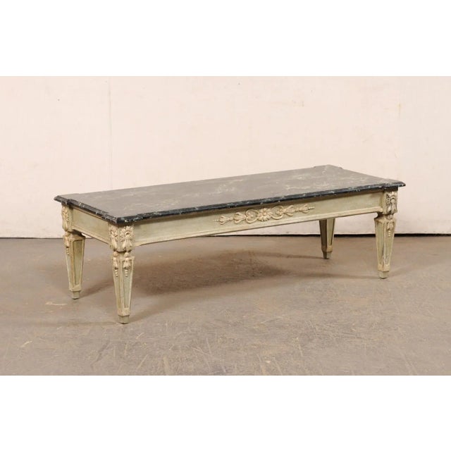 A vintage American coffee table with faux marble top and floral accents. This coffee table, approximately 4.5 feet in...
