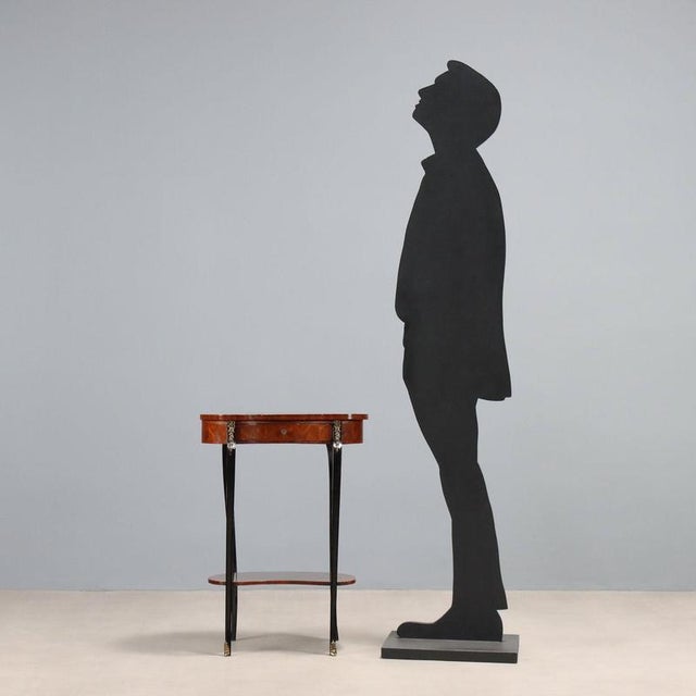 Bean-shaped coffee table, veneered in segmented mahogany with maple trim. Drawer in the lower section, ebonized legs with...