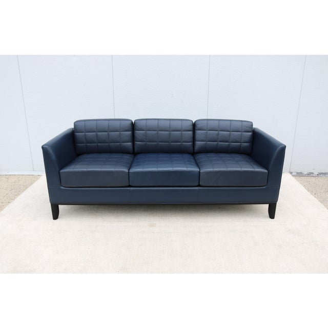 Striking mid-century modern style three-seater Moreau sofa tailored in premium deep navy blue leather, designed by Mark...