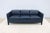 Striking mid-century modern style three-seater Moreau sofa tailored in premium deep navy blue leather, designed by Mark...
