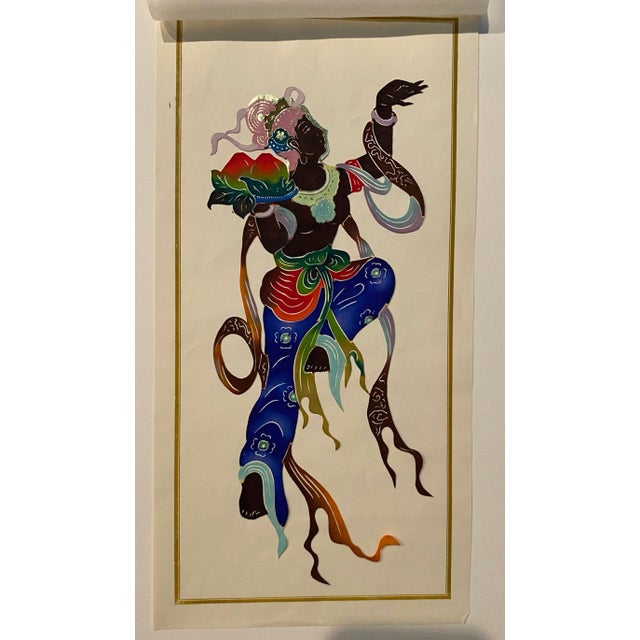 Chinese cut out of a deity made of painted and cut thin paper. The cut out come with between tissue paper and a backing...