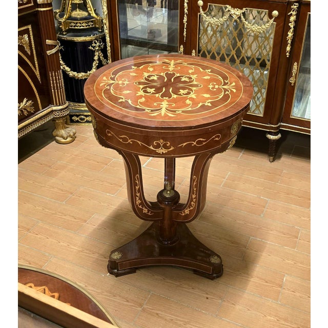 Bring timeless European elegance into your home with this exquisite French Empire style round accent table. Featuring a...