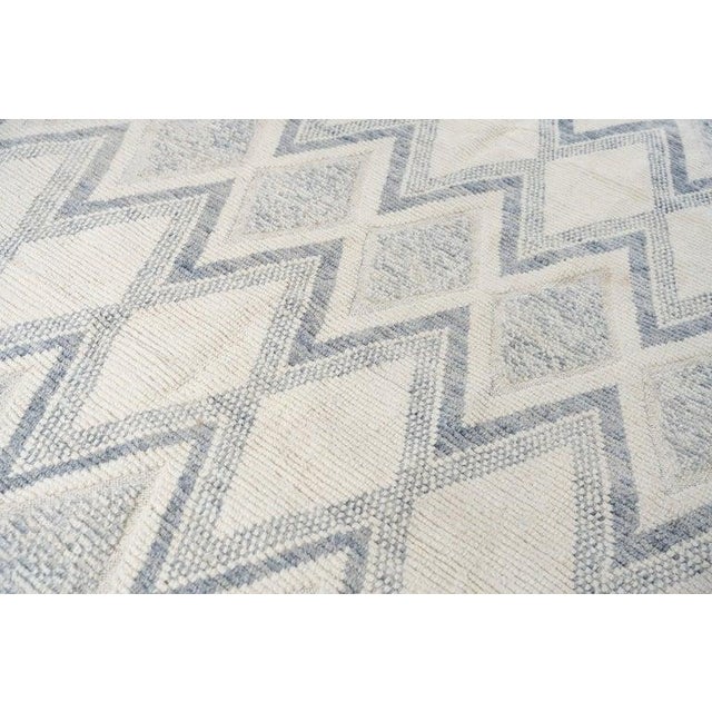 This hand knotted pile rug originates from Pakistan and features a primary color palette of ivory, beige, cream, and...