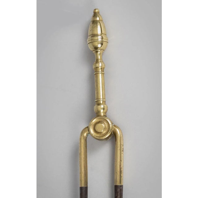 Antique 19th Century American brass and steel fireplace acorn topped tongs. It has a large amount of brass and the acorn...