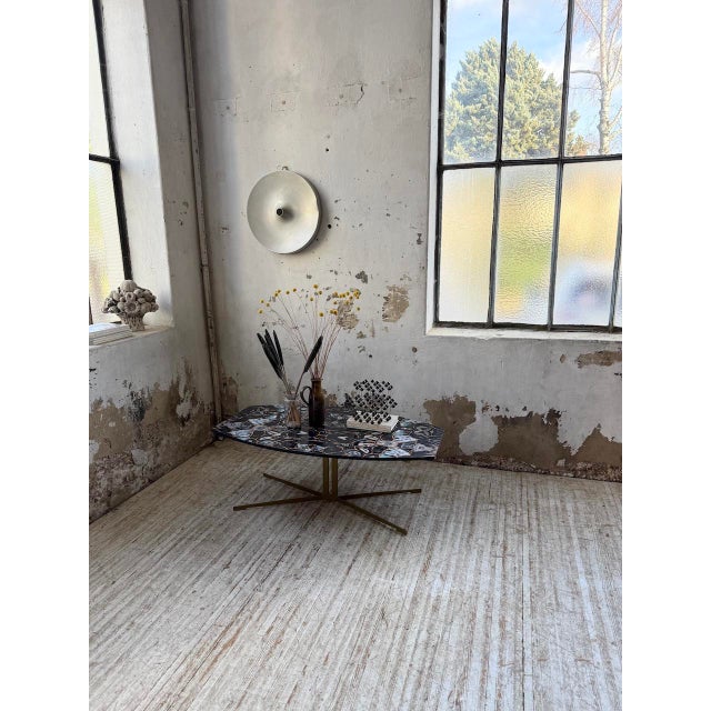 A 1990s coffee table with a gold-colored metal cross base (gold paint) and a wooden top with an agate stone-effect finish....