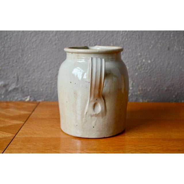 We imagine this large stoneware pitcher on a beautiful farm table with an assertive patina. This common ceramic is...