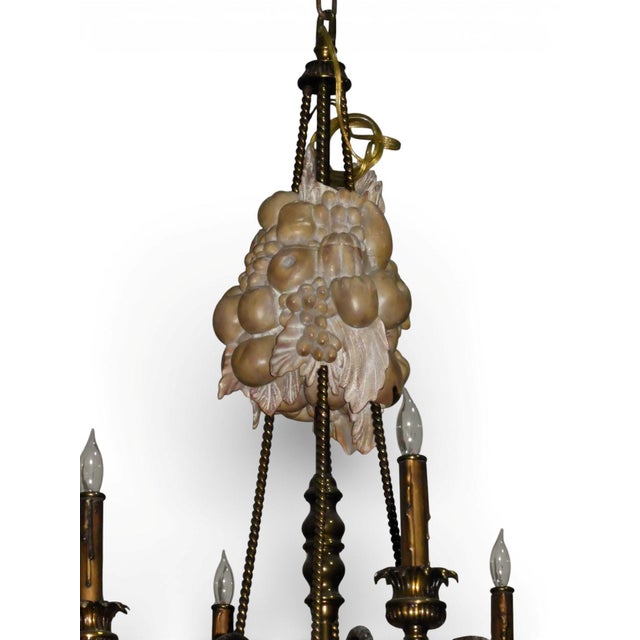 A stunning Maitland Smith 8-light chandelier. Brass arms with flower-like bobeche at the base of each bulb. Cast resin...