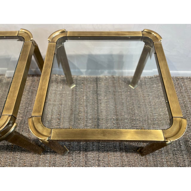 A pair of vintage side tables by Mastercraft Furniture featuring a brass frame with softly curved corners is a stylish...