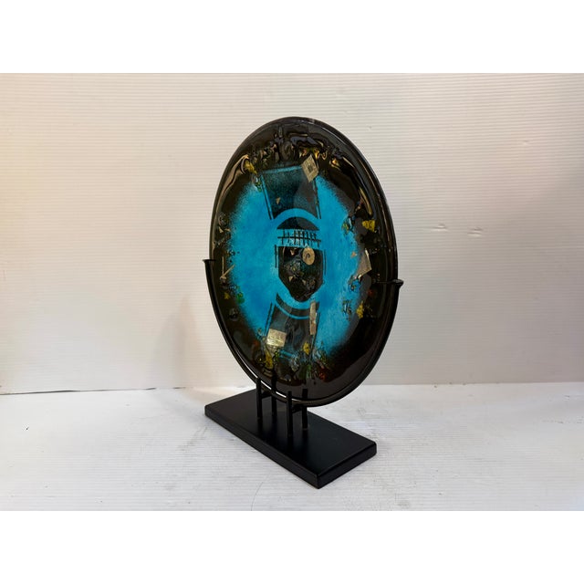 This fused glass platter is a statement piece in any space, with stunning inlays and vibrant blue center. The platter rest...