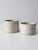 Pair of antique white stoneware crocks with creamy glaze, rounded rims, and classic cylindrical forms. Subtle glaze...