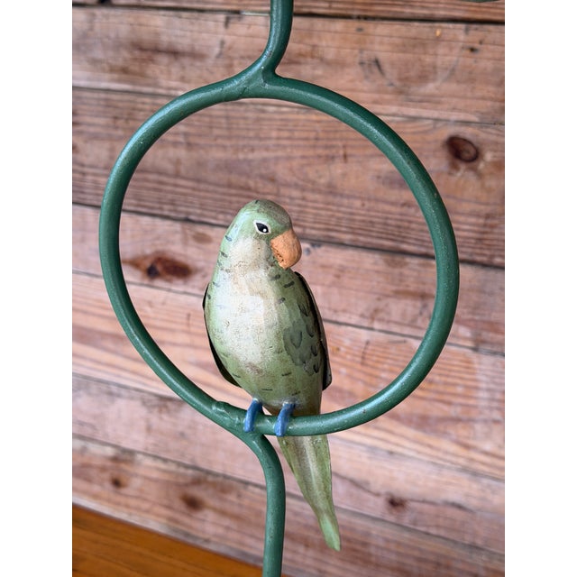 Charming pair of vintage tropical parakeet table lamps featuring hand-painted metal birds perched within sculptural...
