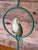 Charming pair of vintage tropical parakeet table lamps featuring hand-painted metal birds perched within sculptural...