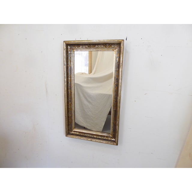 This silverleafed mirror has a Fortuny style stenciled design in the cove and measures 27'H x 15.75"W.