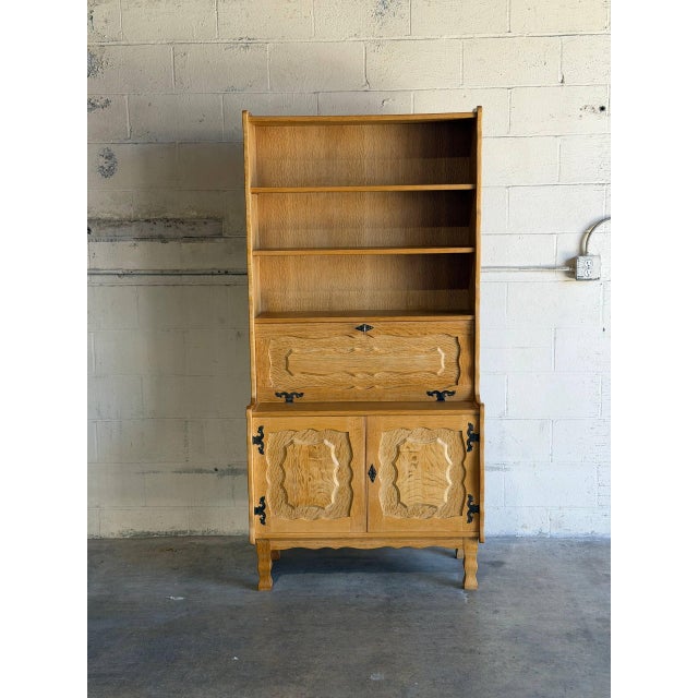 Featuring open upper shelving above a drop-front secretary desk and lower cabinet doors, this versatile piece offers...