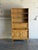 Featuring open upper shelving above a drop-front secretary desk and lower cabinet doors, this versatile piece offers...