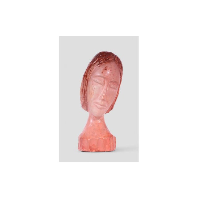 This captivating plaster sculpture depicts a delicate female face, created by the artist Enzo Bisi, as indicated by the...