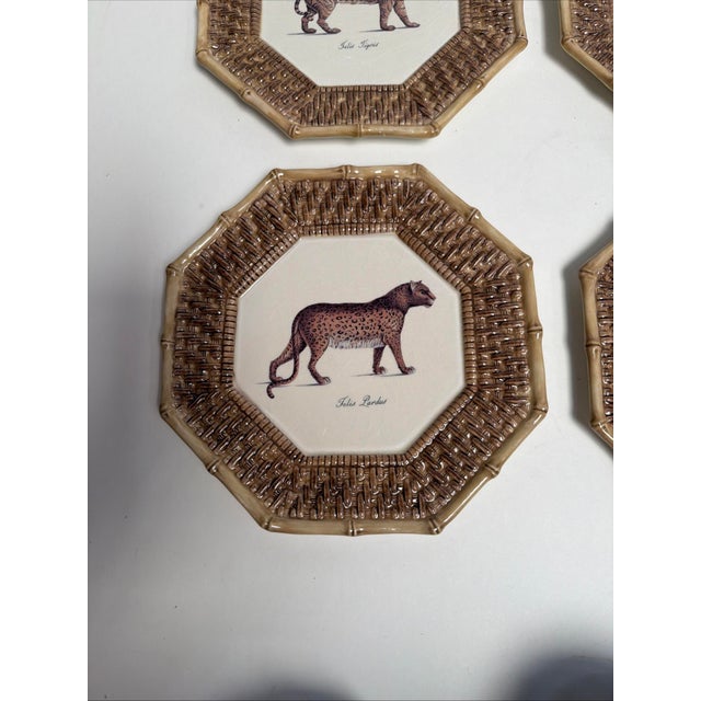 The product is a set of four vintage Raymond Waites Empire plates featuring a safari pattern with brown rattan and tiger...