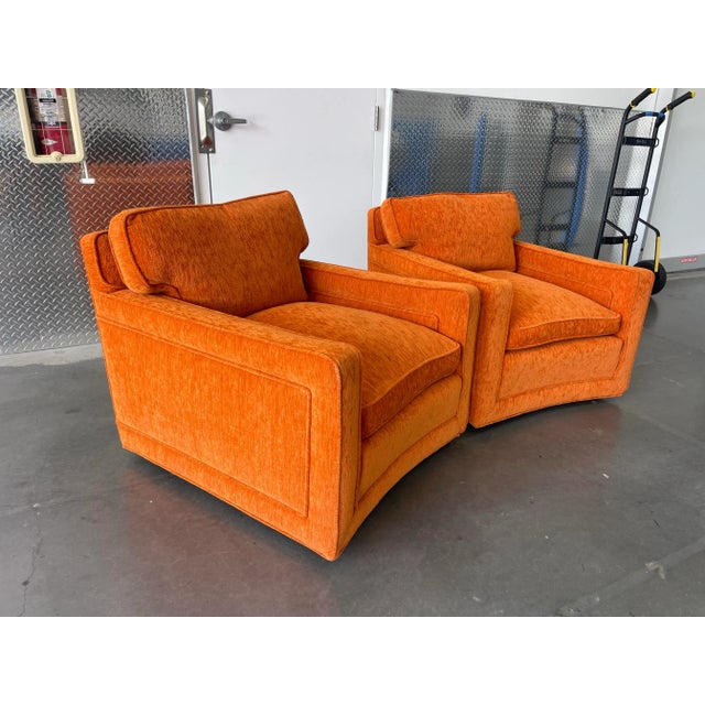 A substantial and beautifully tailored pair of 1970s low-profile lounge chairs featuring custom burnt orange upholstery...