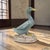 A vintage Chinese figural sculpture depicting a standing goose or duck, executed in painted chalkware with inset glass...