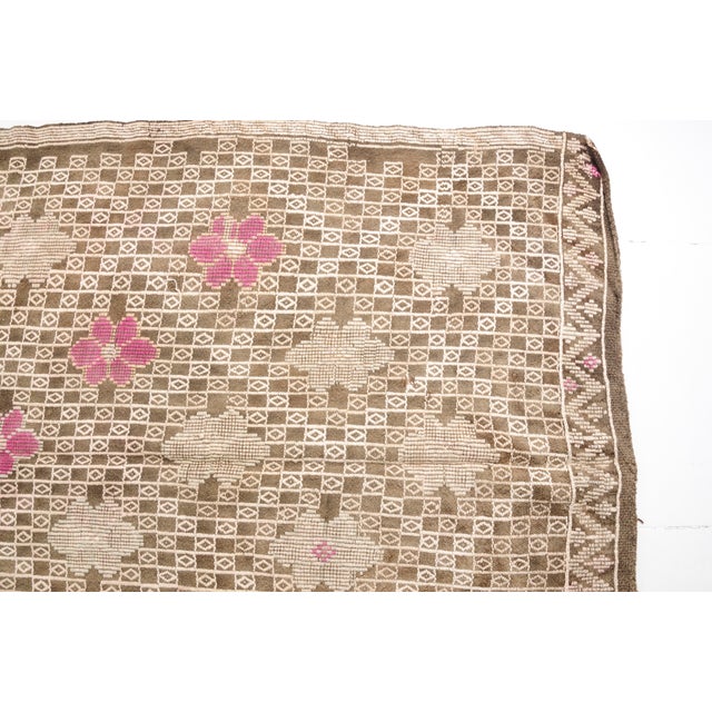This is a vintage Turkish Oushak rug from the Mid 20th Century. The piece was hand-knotted.